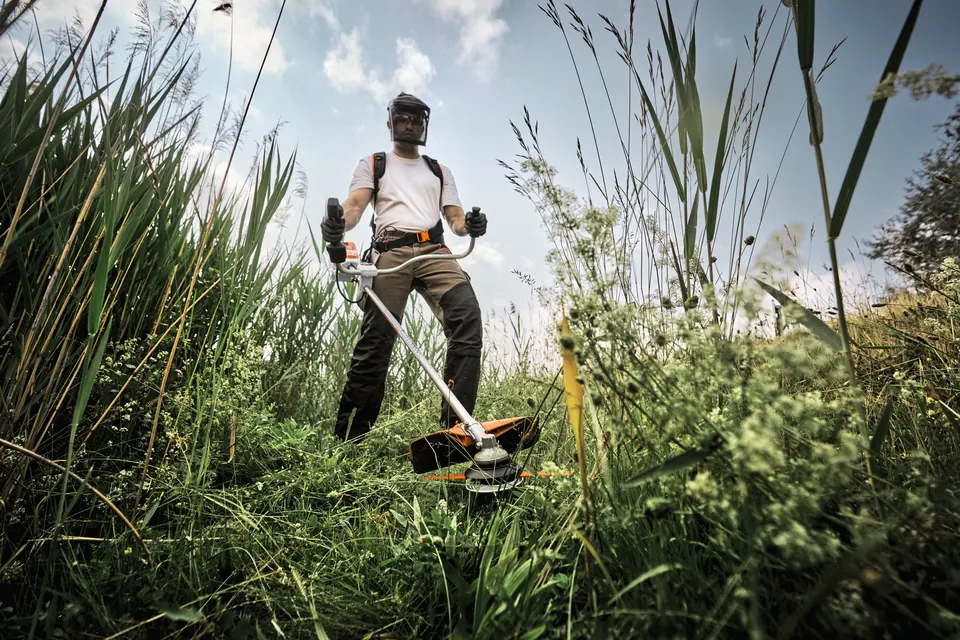 STIHL Akku-Motorsense FSA 140 R bei der Grünflächenpflege im Sommer