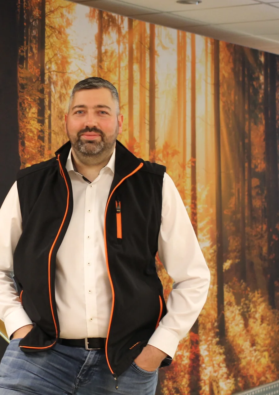 Steffen, STIHL-Fachberater bei WMS in Schwaigern, vor der STIHL-Wand im Ladengeschäft
